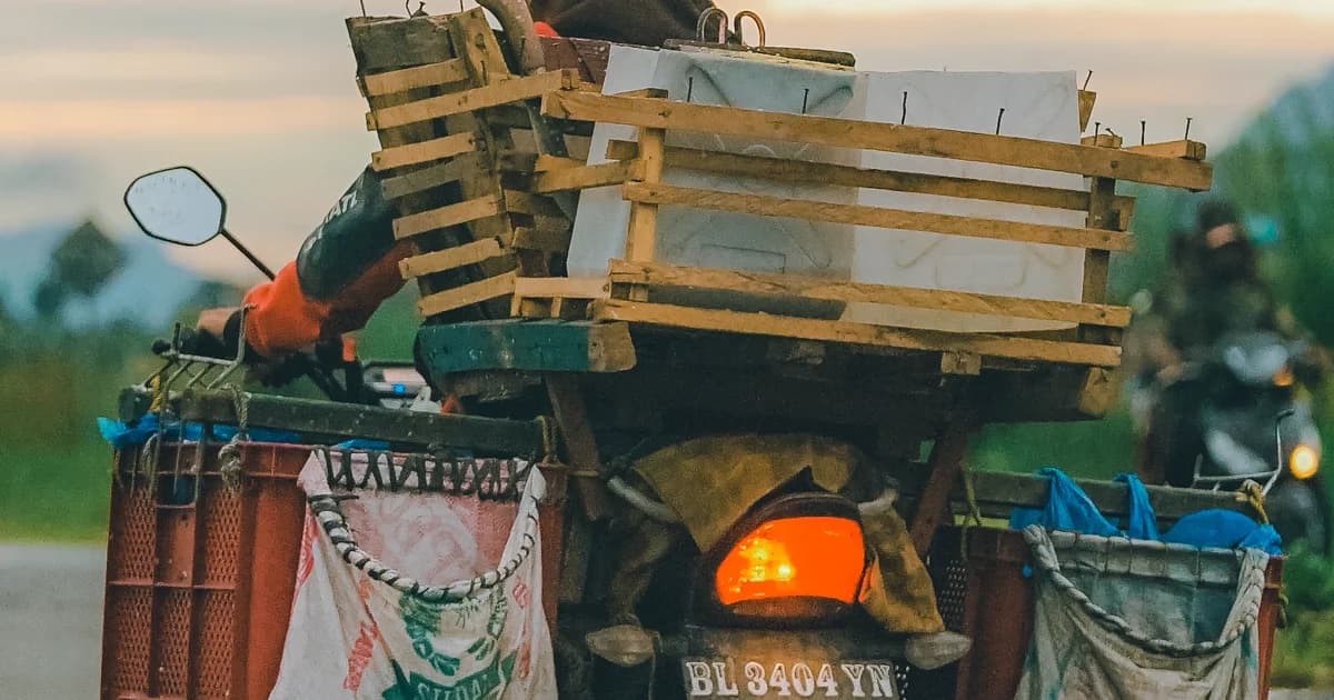 Motociclista transportando engradados amarrados em moto