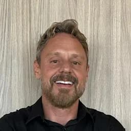 Sergio Arantes, de camisa preta, sorrindo