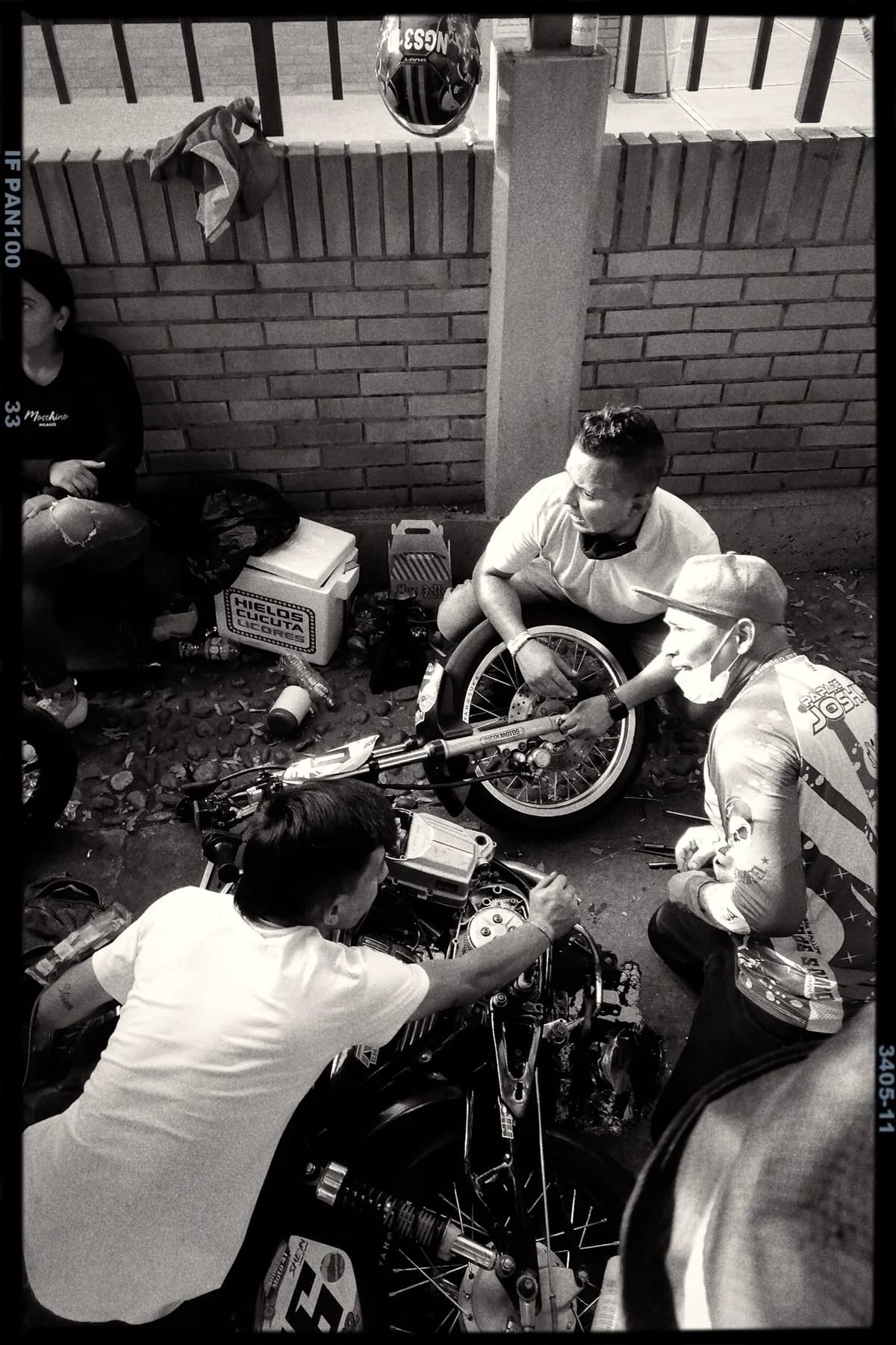 Grupo de homens reparando moto em rua