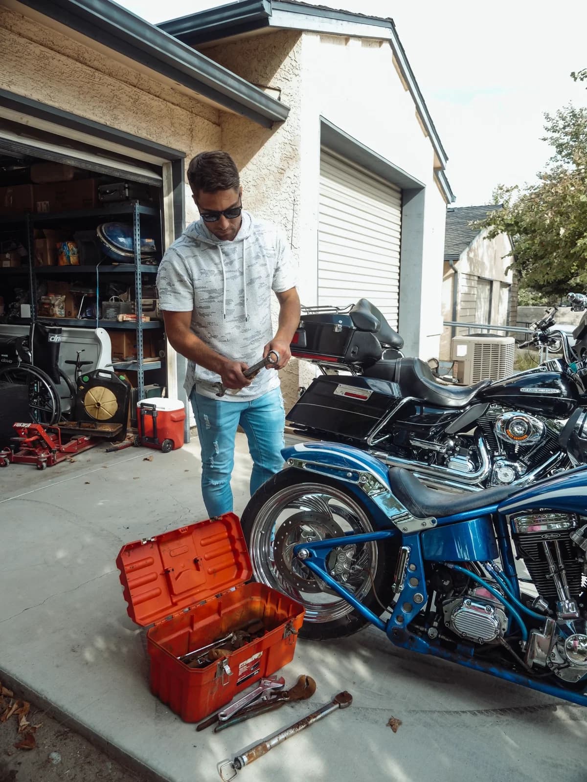 Homem trabalhando em moto em garagem com ferramentas ao redor