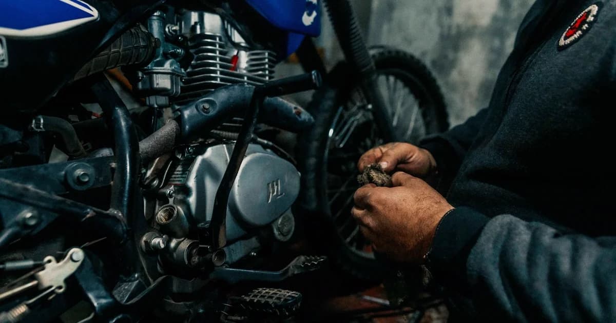 Mecânico trabalhando no motor de moto em garagem