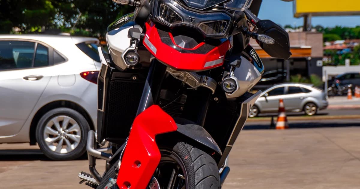 Moto esportiva estacionada em rua da cidade em dia de sol