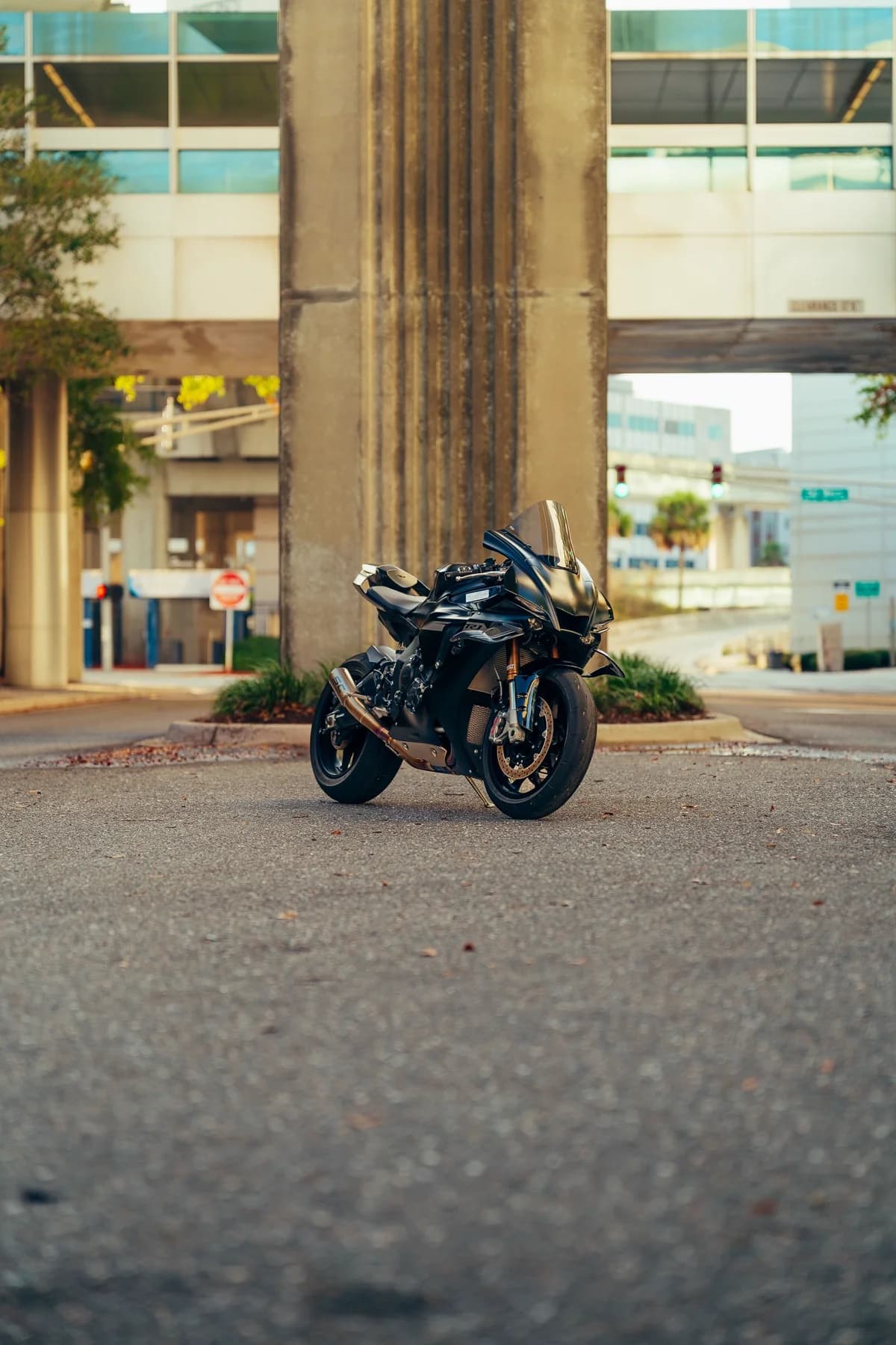 Moto preta estacionada em rua da cidade com prédios ao fundo