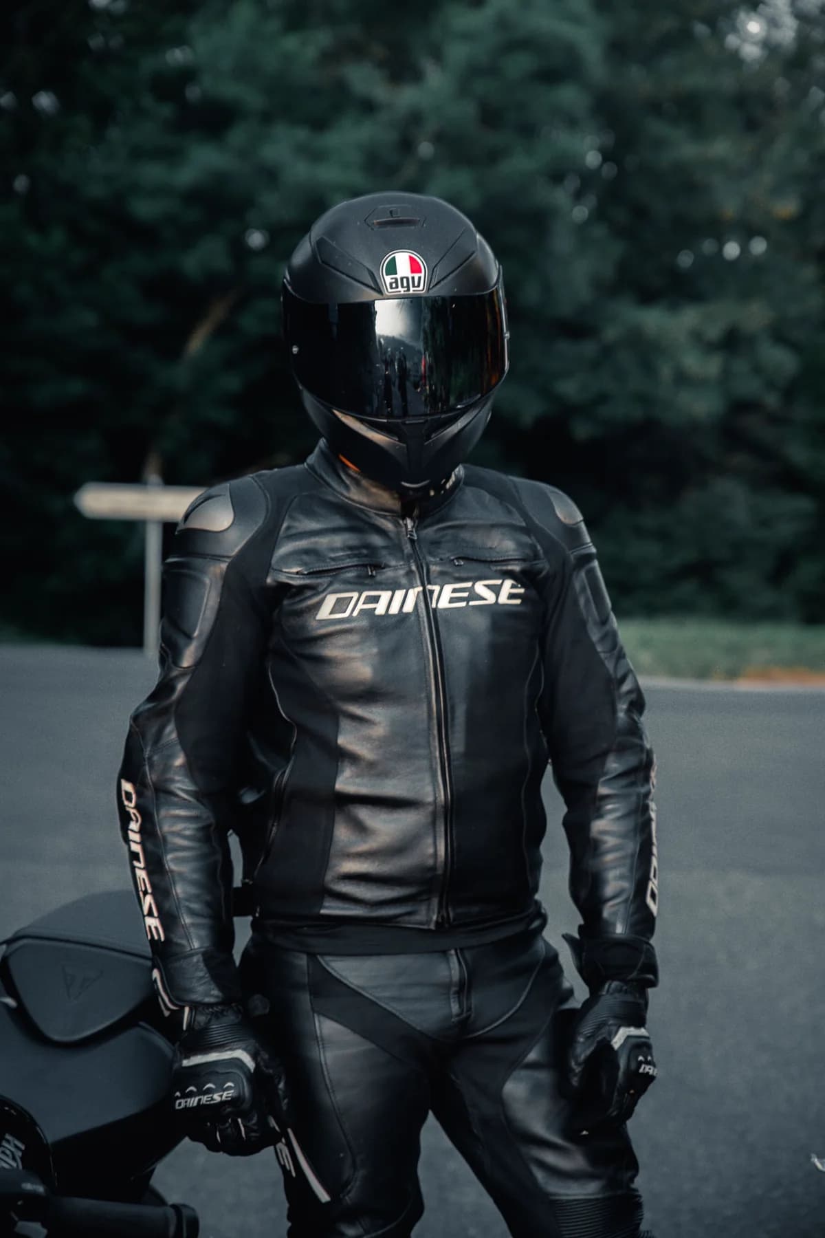 Detalhe de piloto com jaqueta de couro e capacete preto ao ar livre