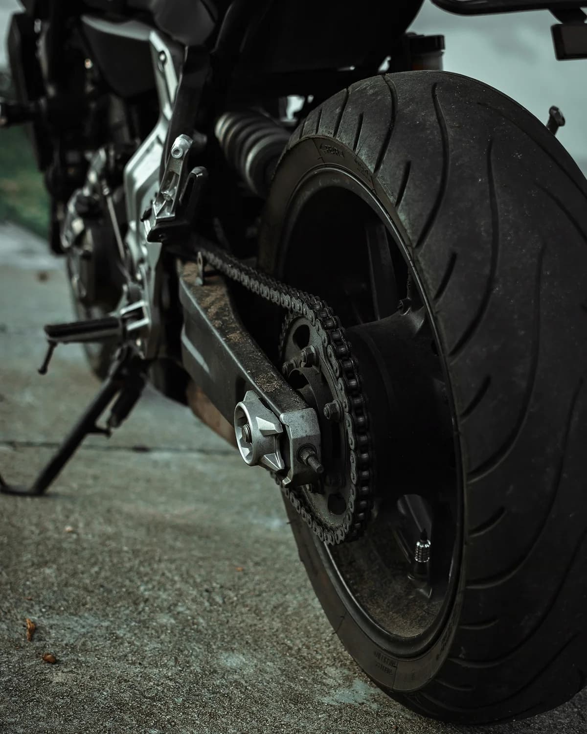 Pneu e corrente de moto em close