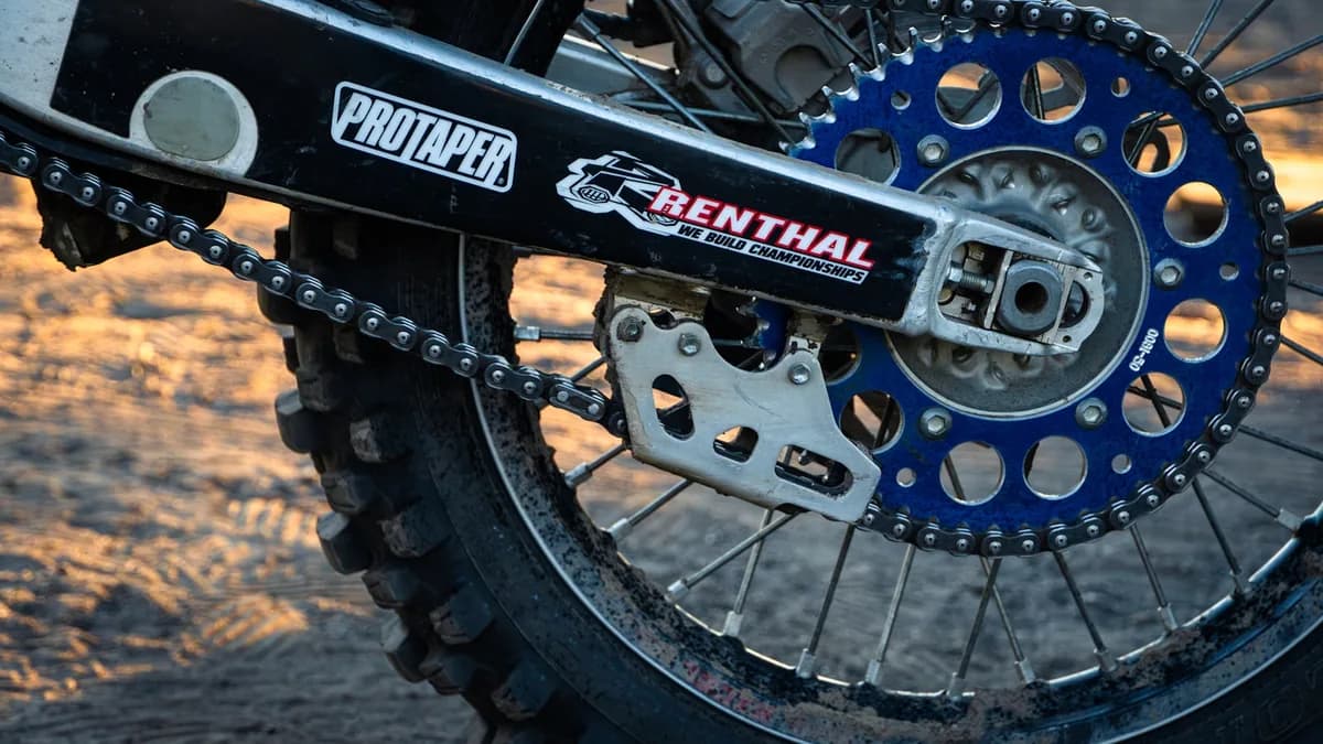Corrente, guia e coroa de moto off-road cobertas de barro seco