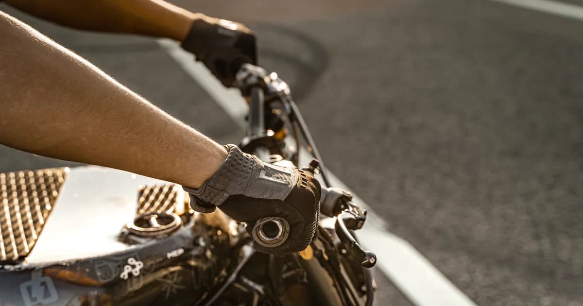 Mãos de motociclista com luvas no guidão em movimento