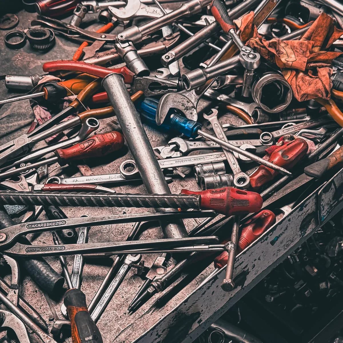 Bancada de garagem doméstica com ferramentas manuais variadas sobre a mesa