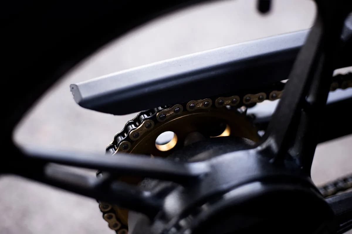 Close da corrente e da coroa de uma moto, com os elos em foco
