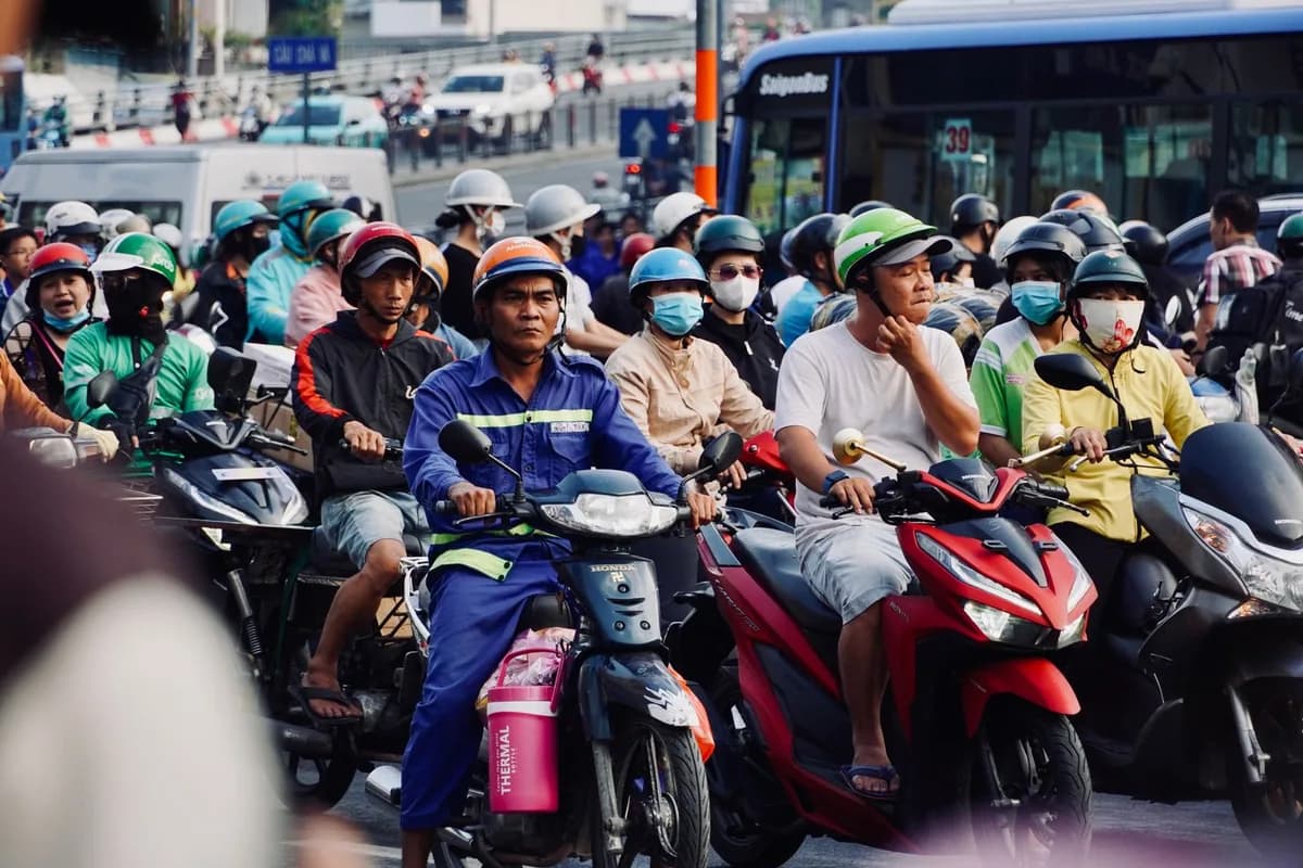 Trânsito urbano carregado de motos e scooters parado no semáforo em hora de pico
