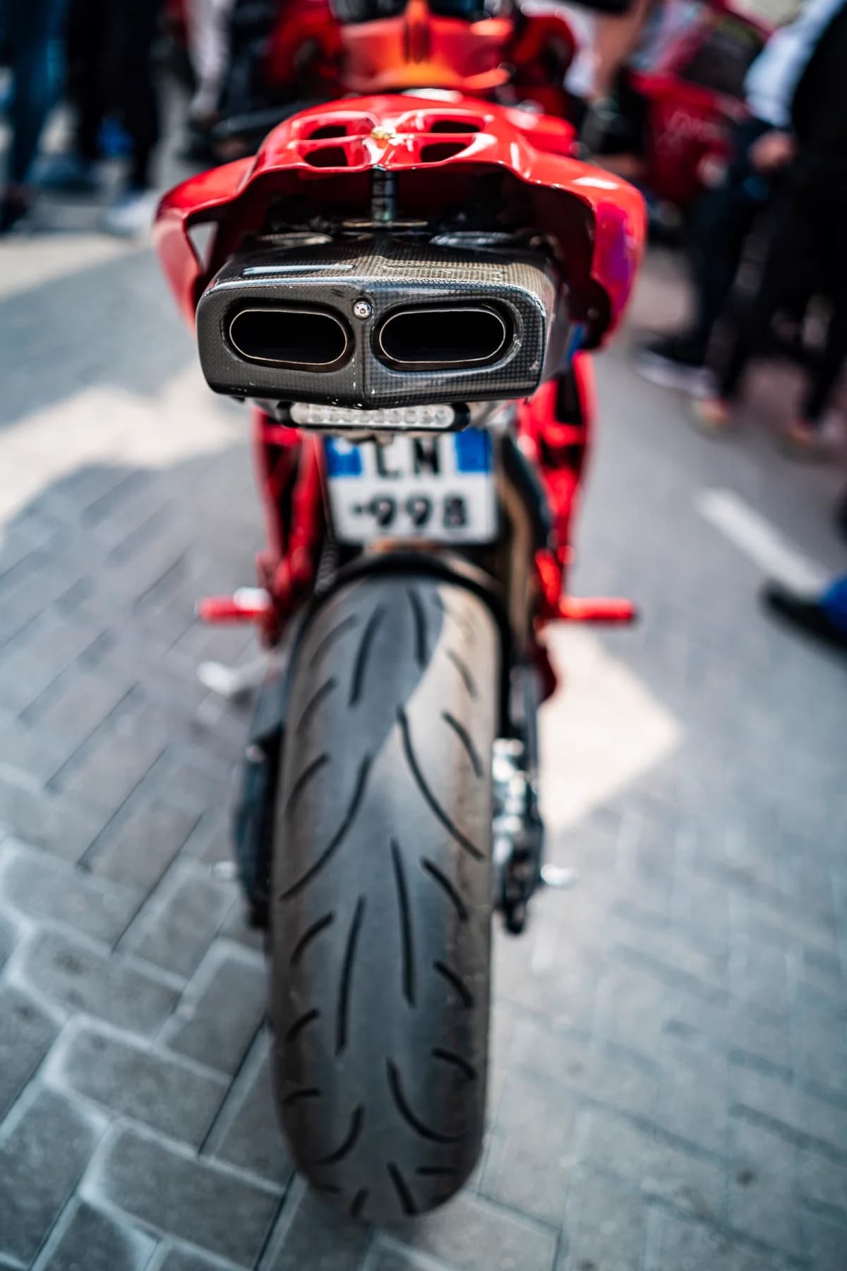 Pneu traseiro e escapamento de moto em rua pavimentada