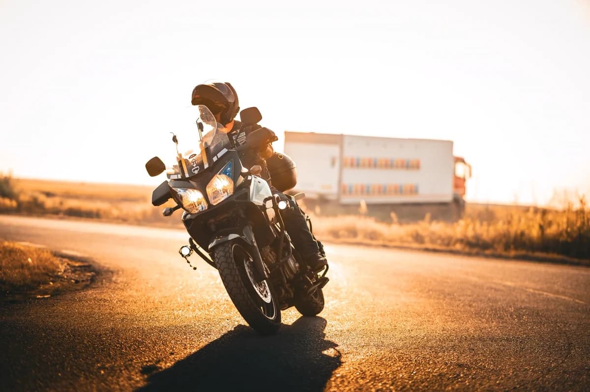 Motociclista em estrada cênica ao nascer do sol