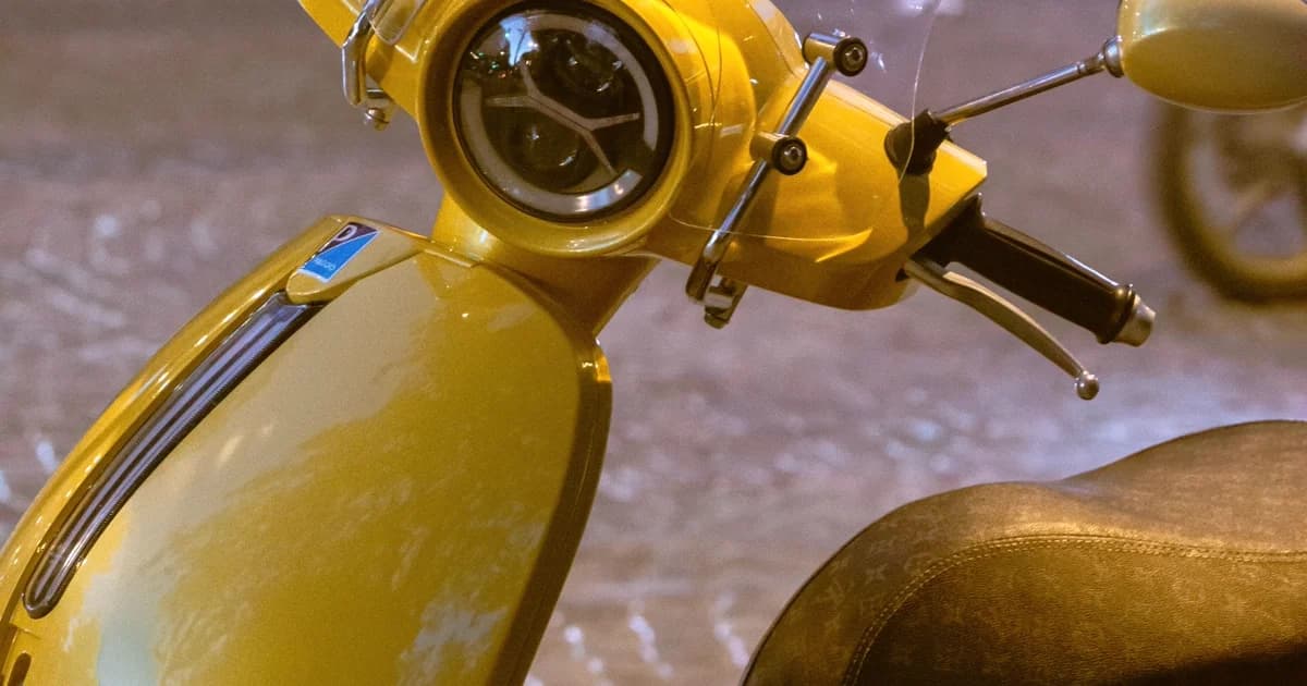 Scooter amarela estacionada em rua urbana ao entardecer