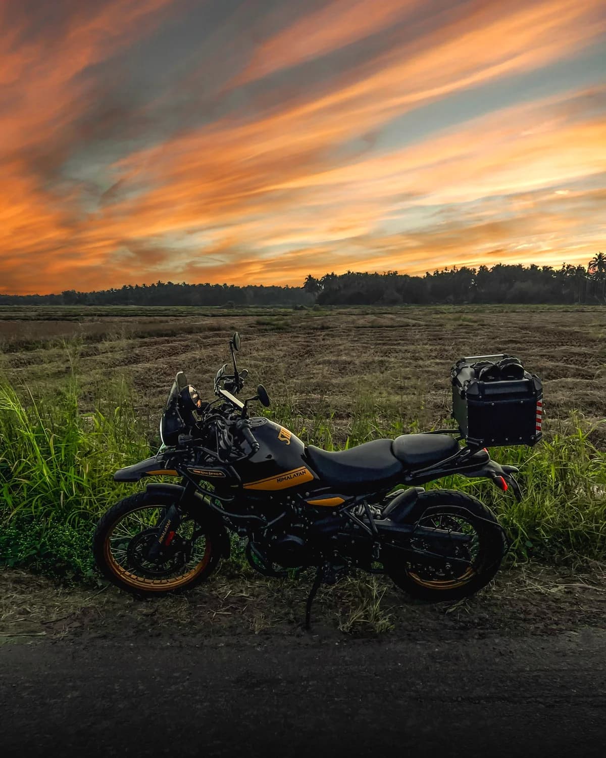 Moto estacionada em estrada de terra ao pôr do sol