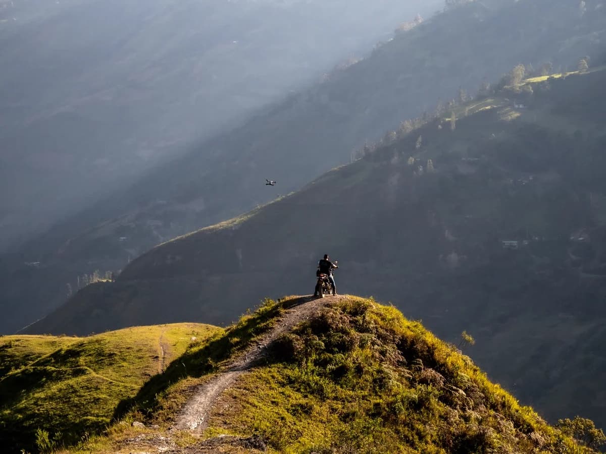 Moto solitária em trilha de montanha sob sol