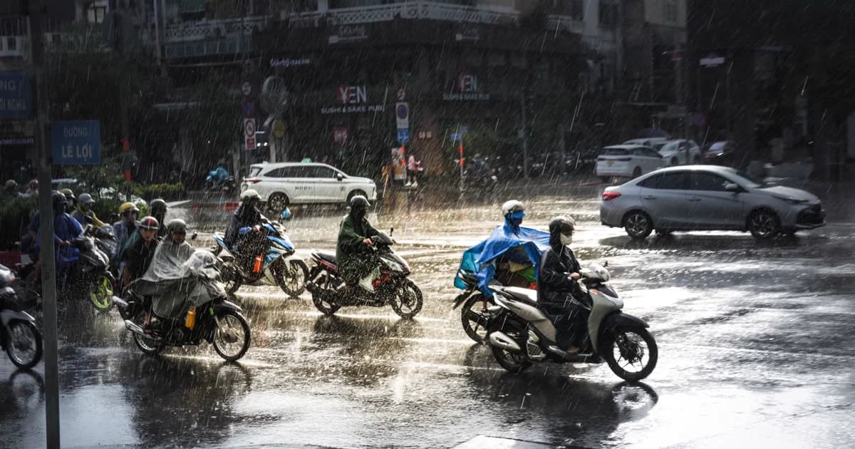 Motociclistas pilotando sob temporal forte em avenida de cidade