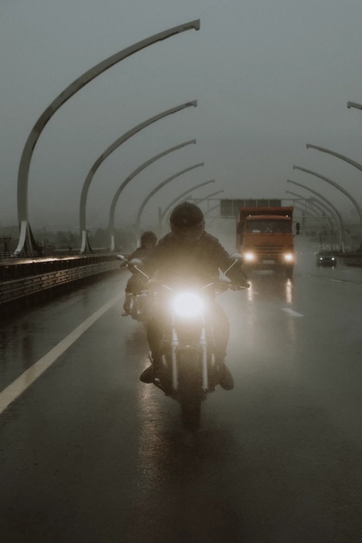 Pilotos em motos sobre pista molhada em dia de chuva