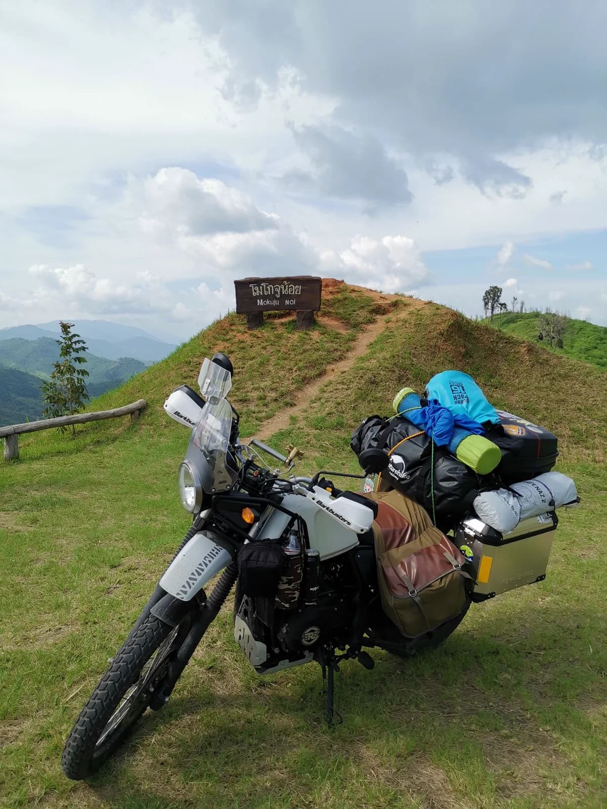 Motocicleta preta e cinza estacionada em campo verde antes da viagem